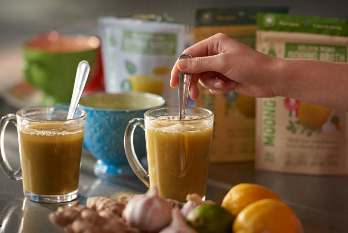 Two cups of Moong Pani golden mung broth being stirred