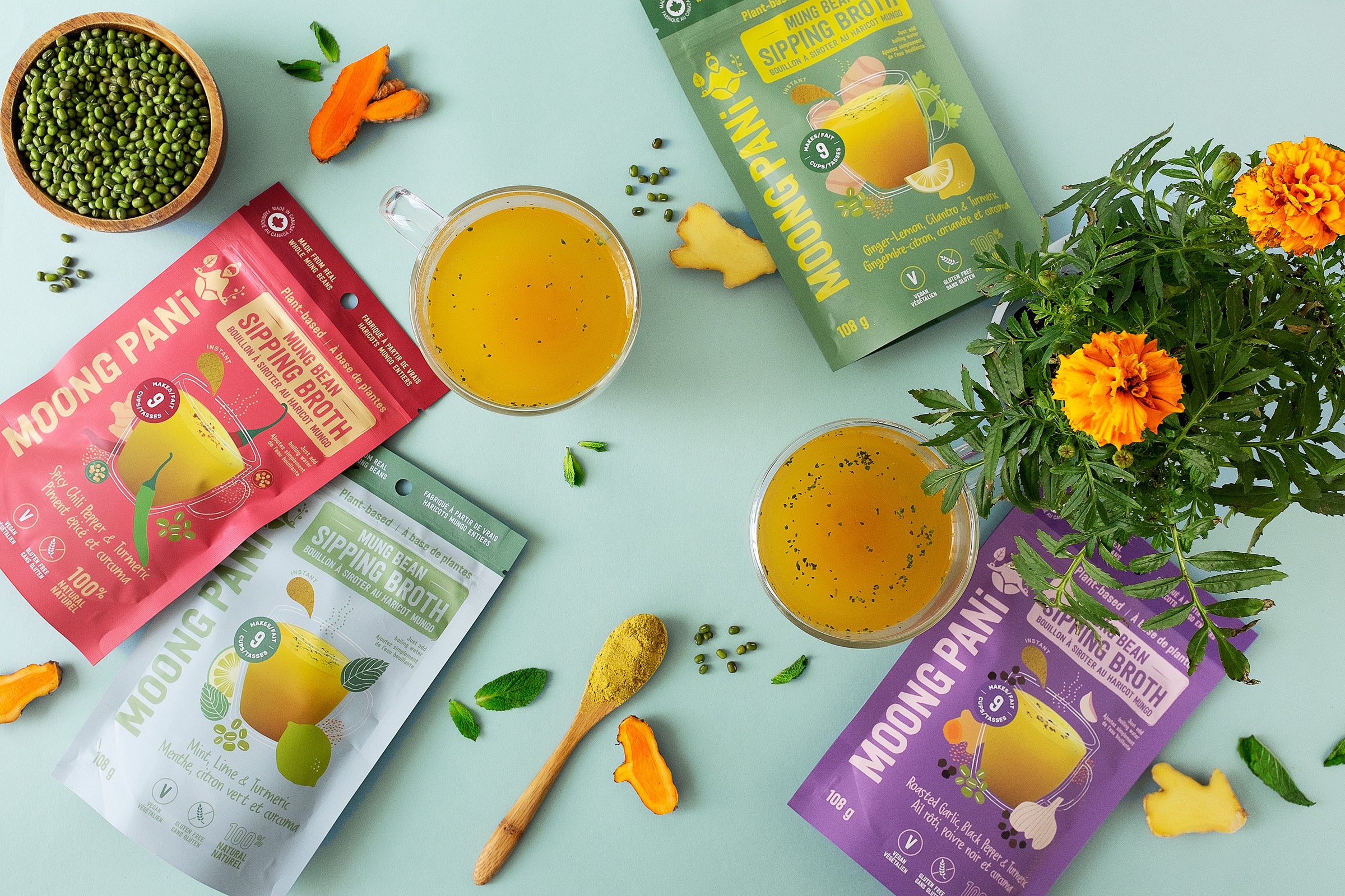 Various packets of Moong Pan, a health drink, on a light green background with flowers and a cup of the drink.